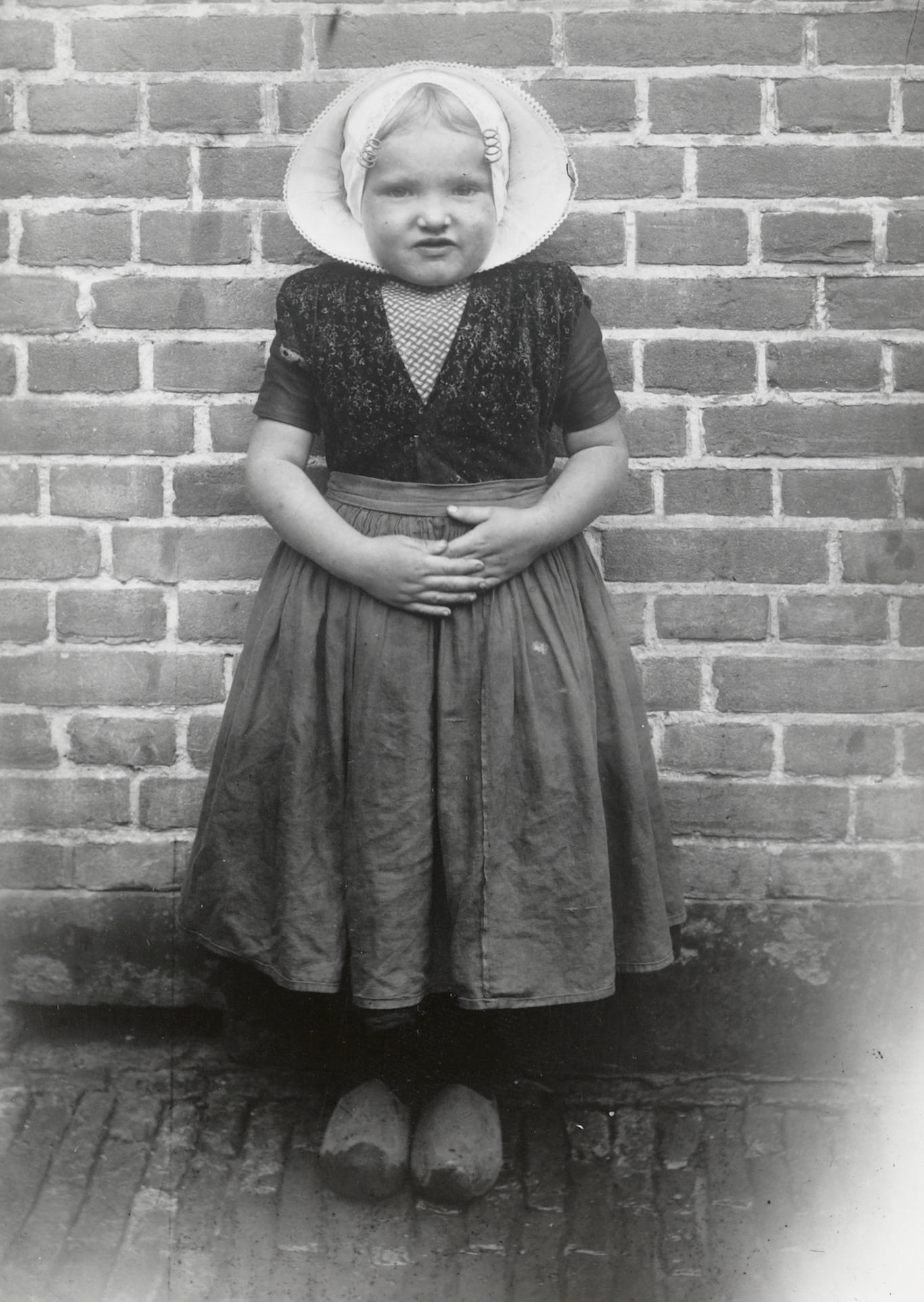 Meisje in Arnemuider streekdracht, 1913–1916 (zwart-wit foto)