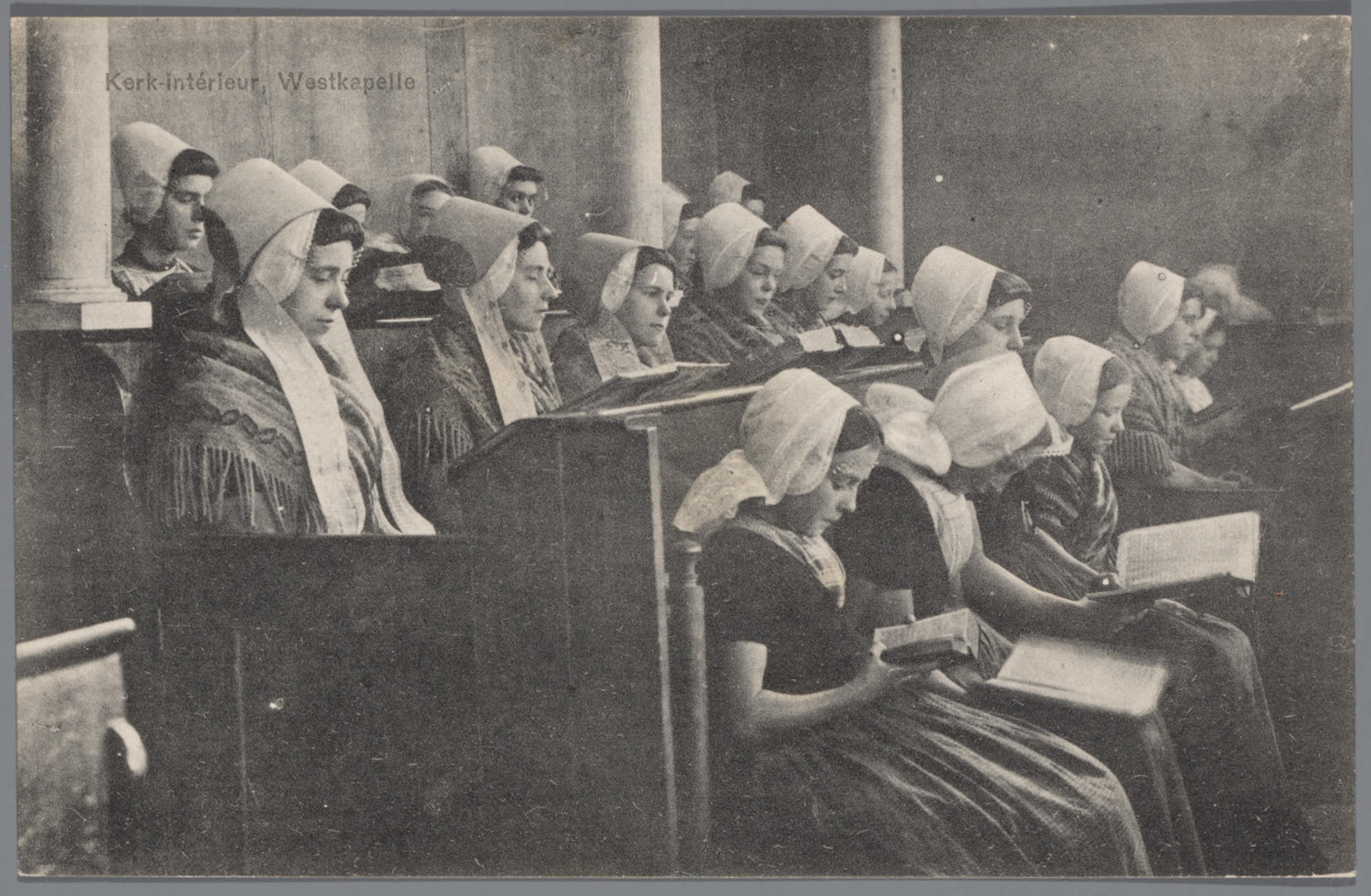 Kerkinterieur met vrouwen en meisjes in Walcherse dracht, 1905–1949 (ansichtkaart)