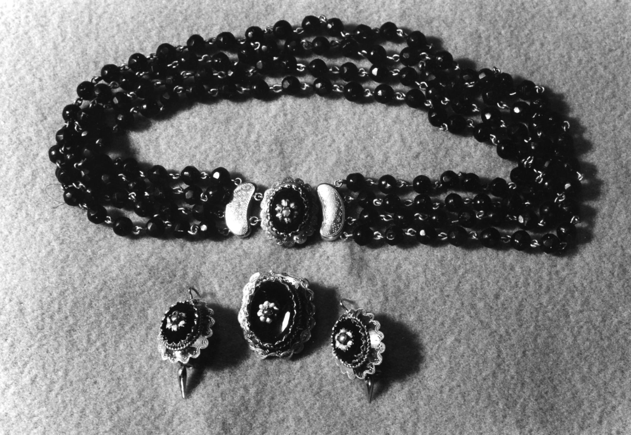 Oorbellen, broche en halssnoer, gedragen op Tholen, 1955 (zwart-wit foto)